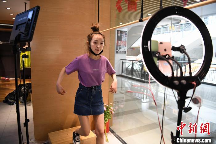 图为一家服装贸易公司内,员工在直播平台上带货。 康平 摄