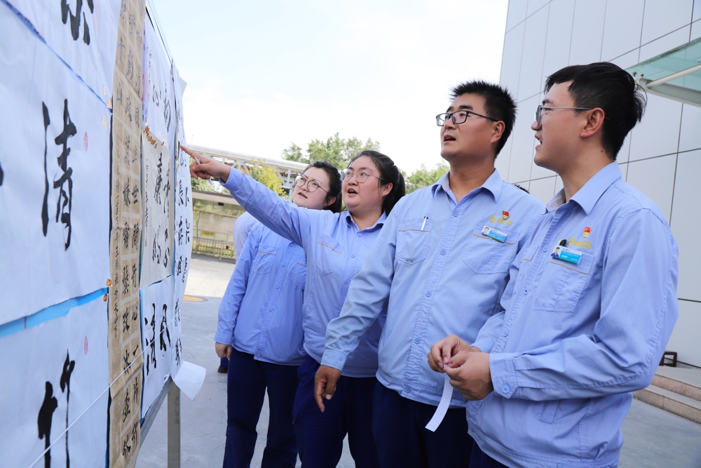 图二、7月14日，天伟化工有限公司举办的“笔墨抒廉志 丹青守初心”廉洁文化作品展，集中展出来自各基层单位职工创作的绘画、书法、剪纸、摄影等各类作品80余件，图为职工在书法作品前驻足观看交流。（贾雪萍摄）