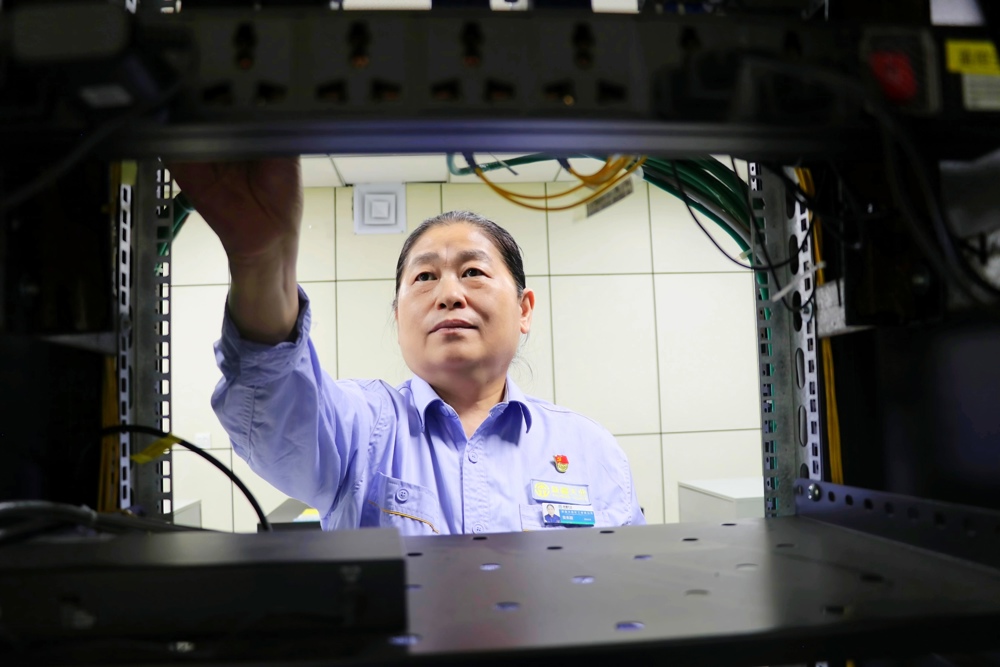图二为天能化工DCS高级工程师安丰颖检查机柜内部线路与设备配件。