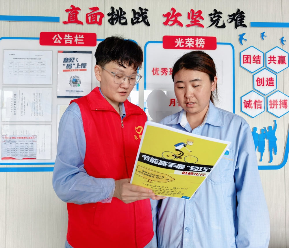 图为：天伟化工厂氯碱团支部志愿者正在向岗位职工分享日常低碳生活小妙招。（俞倩娜 摄）