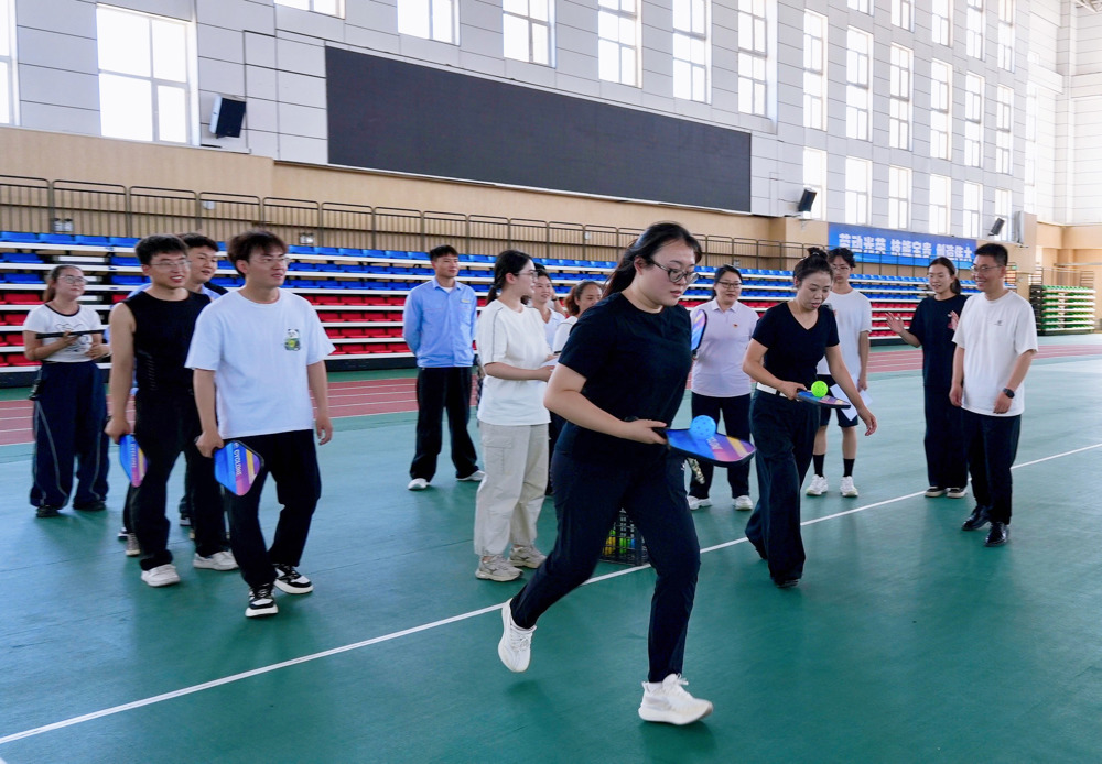 图为：石河子工程职业技术学院教职人员与天业汇合党员及青年团员代表进行素质拓展