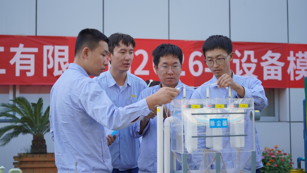 图二：职工们在脉冲布袋除尘器模型前亲手实践，热切交流。（樊新花摄）