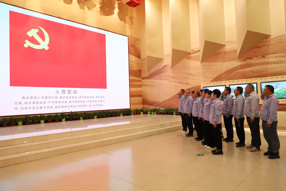 图二为活动现场，全体党员重温入党誓词。