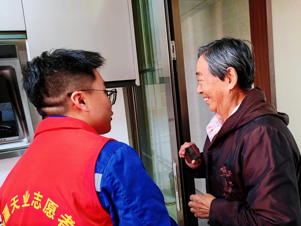 图2为志愿者给老人宣传防诈骗知识