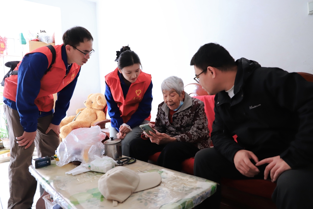 图为青年志愿者指导老年长辈学习智能手机（温亚芳_摄）