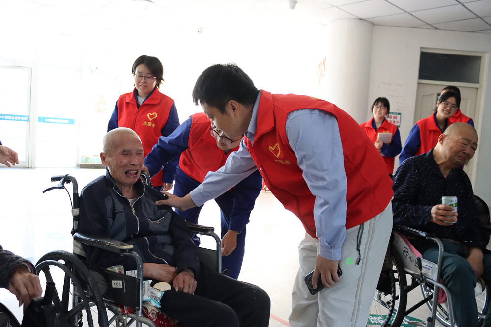 图为：志愿者安抚老人情绪